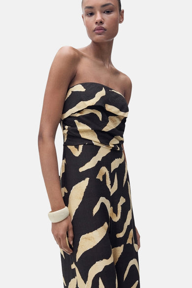 Combinaison noire de MANGO avec un imprimé zèbre beige remarquable et un design sans bretelles, incluant une bandeau blanche.