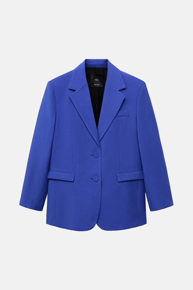 Blazer bleu de MANGO, avec une doublure noire et deux boutons, sur un fond blanc.