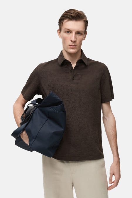 Polo marron à manches courtes de MANGO, avec une subtile texture et un col classique à l'arrière.