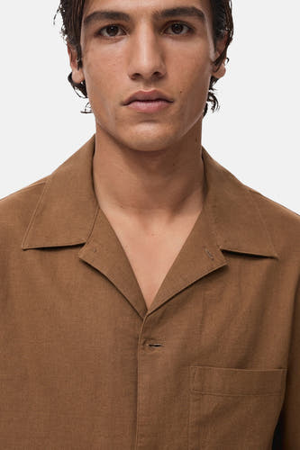 Chemise brune à manches courtes de MANGO, avec un col ouvert et une poche poitrine en en version versionée.