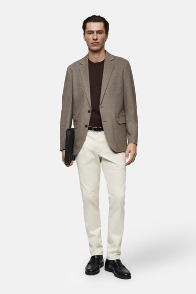 T-shirt brun à manches courtes de MANGO, porté sous un blazer avec un pantalon blanc et des chaussures noires.