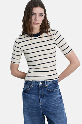 T-shirt rayé blanc avec manches courtes de MANGO, associé à un jeans bleu.