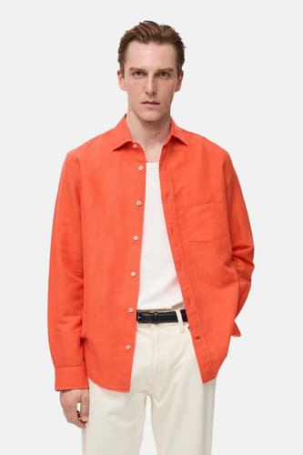 Chemise orange à manches longues de MANGO, portée avec un T-shirt blanc et une légère avec pantalon ce.