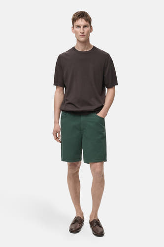 Short vert de MANGO, porté avec un T-shirt marron et des loafers marrons.