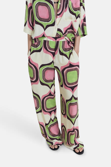 Pantalon multicolore de MANGO avec un motif géométrique rétro en vert, rose et marron.