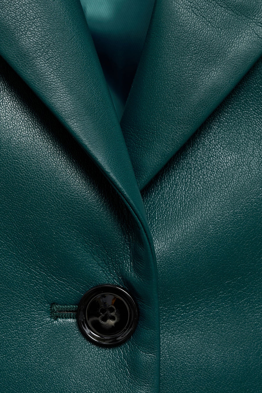Blazer courte bleu de MANGO, avec une fermeture à un bouton et un col à revers en cuir lisse.