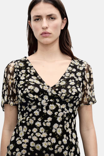 Robe noire à manches courtes de MANGO, ornée d'un motif de marguerites blanches et d'une encolure V.