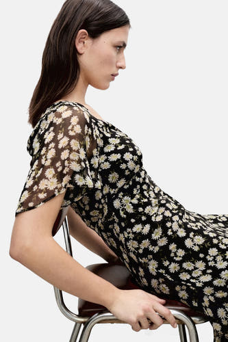 Robe noire à manches courtes de MANGO, avec un imprimé fleuri et une matière fluide et transparente.