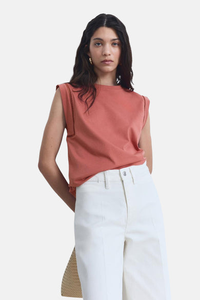 T-shirt sans manches rose de MANGO, avec des détails décoratifs sur les épaules, associé à une jupe blanche.