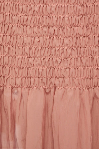 Roze, gesmokte stof met plooien.
