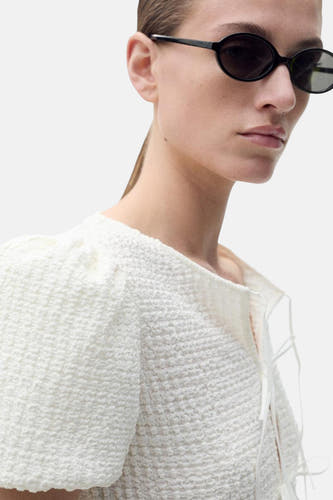 Blouse blanche à manches courtes de MANGO, avec une texture tissée et des bandes décoratives.