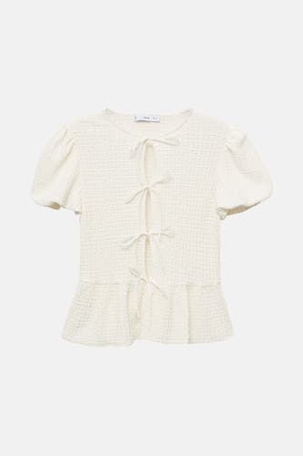 Blouse blanche à manches courtes de MANGO, avec des détails boutonnés et des manches bouffantes.