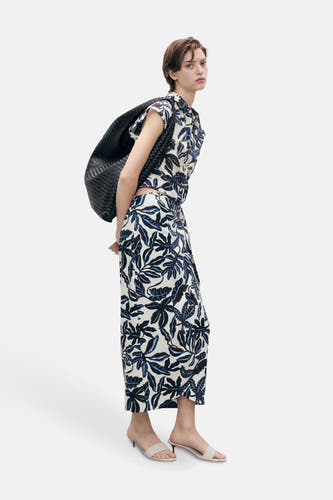 Robe multicolore de MANGO avec un motif de feuilles, associée à une chemise coordonnée et une sac noir.