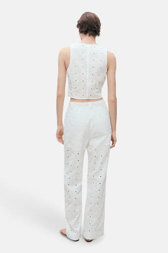 Blouse sans manches blanche de MANGO, avec des détails brodés et un pantalon coordonné.