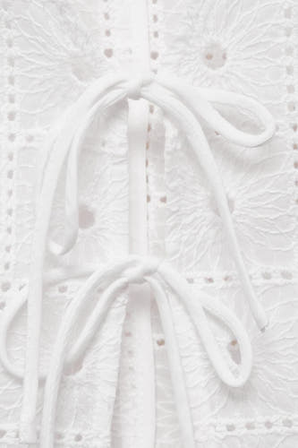Blouse sans manches MANGO, blanche avec broderie anglaise et détails de rayures.