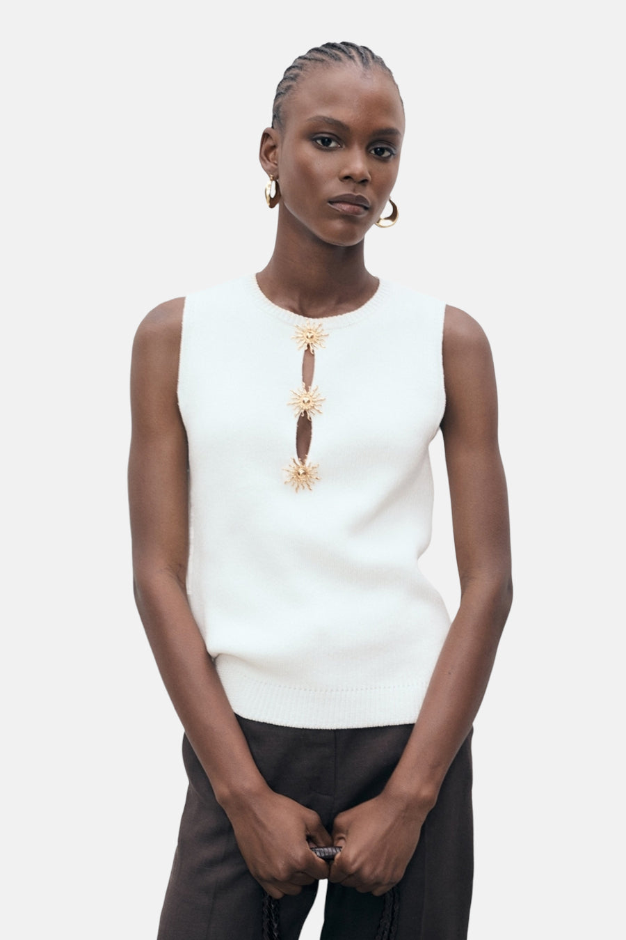 Blouse sans manches blanche de MANGO, ornée de petits soleils dorés et d'une petite ouverture à l'avant.