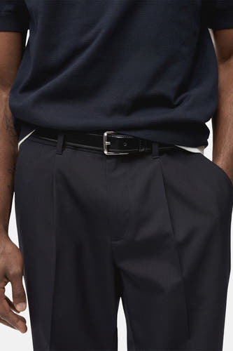 Pantalon de costume bleu MANGO, avec une ceinture en cuir et des plis à l'avant.