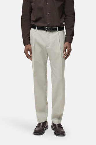 Pantalon gris de MANGO, à plis et avec une ceinture noire, associé à un chemise marron et des chaussures marrons.