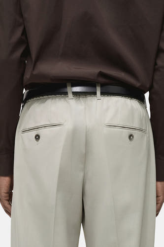 Pantalon de costume gris MANGO, vu de l'arrière avec poches et ceinture brune.