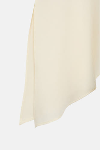 Blouse écru de MANGO, détail de la douce matière et du coupé sans manches.