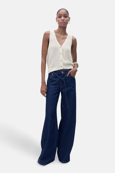 T-shirt écru de MANGO, avec col boutonné, associé à des jeans larges et un unmband argenté.