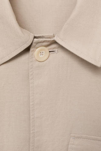 Ecru manteau court de MANGO, avec col et fermeture à bouton, dans un plan rapproché.