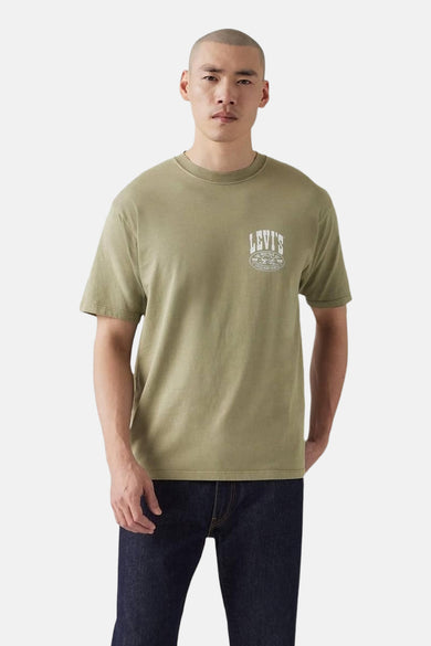 T-shirt Kaki à manches courtes de Levi's, avec une impression blanche sur la poitrine et des jeans foncés.