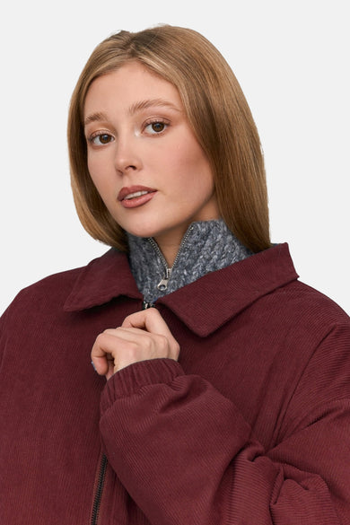 Veste courte rouge de 24 colours GMBH, avec une texture rayée et un haut gris avec une fermeture éclair en dessous.