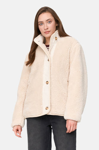 Mauve court manteau de 24 couleurs GMBH, avec fermeture à boutons et texture teddy, porté avec un jeans foncé.