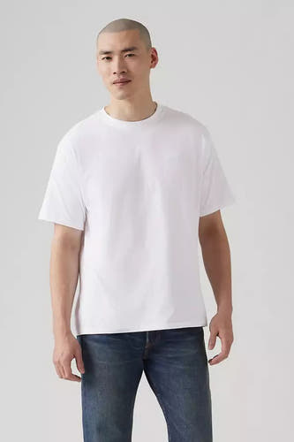 T-shirt blanc à manches courtes de Levi's, porté avec des jeans bleus.