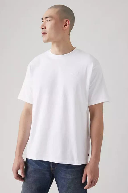 T-shirt blanc à manches courtes de Levi's, porté avec un jean bleu foncé.
