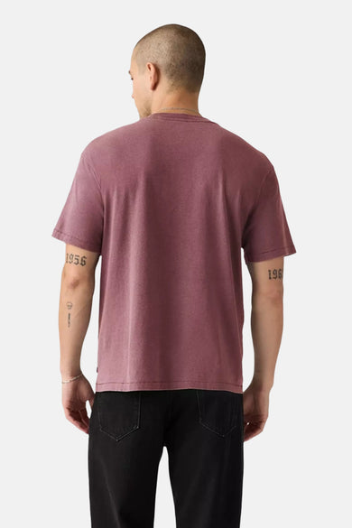 T-shirt rose à manches courtes de Levi's, vu de derrière, avec des tatouages sur les bras et un pantalon noir.