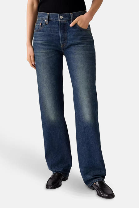 Jean droit bleu marine en denim de Levi's®, avec une ceinture marron et associé à un T-shirt noir.