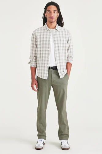 Chino vert de DOCKERS, associé à un T-shirt blanc, une chemise à carreaux et des baskets blanches.