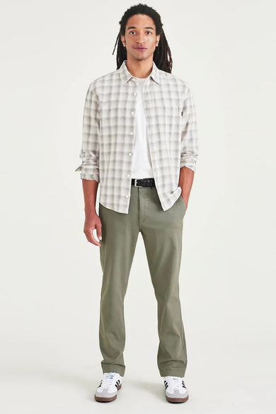 Groene chino van DOCKERS, gecombineerd met een wit T-shirt, geruit overhemd en witte sneakers.
