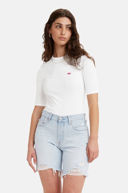 T-shirt blanc à manches courtes de Levi's, porté avec un jean bleu déchiré.