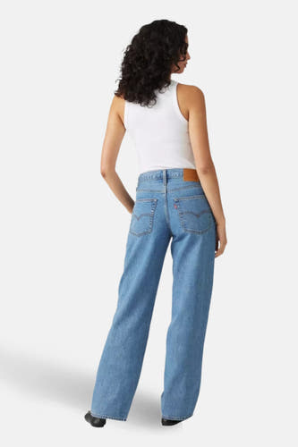 Jean droit mi-bleu denim de Levi's®, vu de derrière, avec un tank-top blanc.