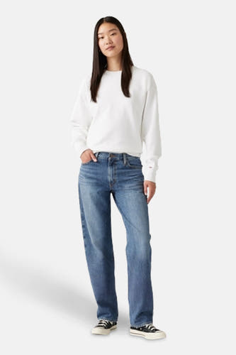 Jean droit en denim bleu clair de Levi's, avec une coupe décontractée et des baskets noires.
