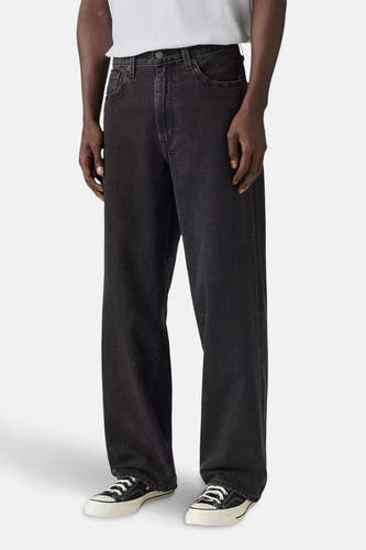 Jean décontracté de denim gris foncé de Levi's®, associé à des baskets blanches et un t-shirt blanc.