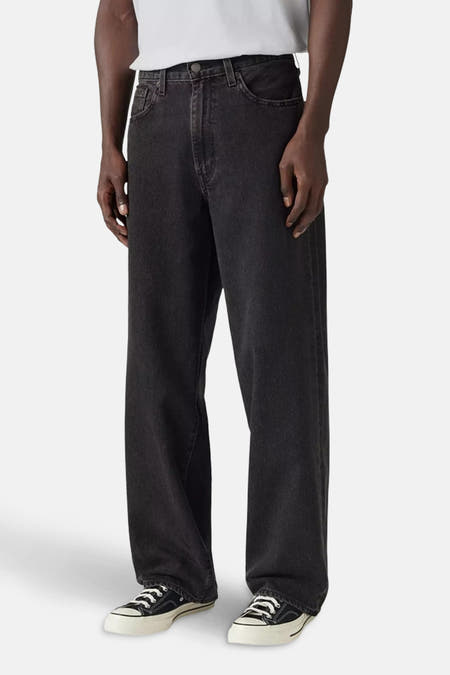 Jean décontracté de denim gris foncé de Levi's®, associé à des baskets blanches et un t-shirt blanc.