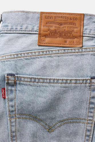 Jean bleu clair large de Levi's, avec étiquette en cuir brun et étiquette rouge sur la poche arrière.