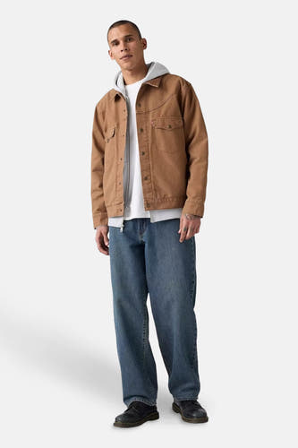 Jean droit en denim bleu marine de Levi's®, porté avec une veste brune et un hoodie gris.