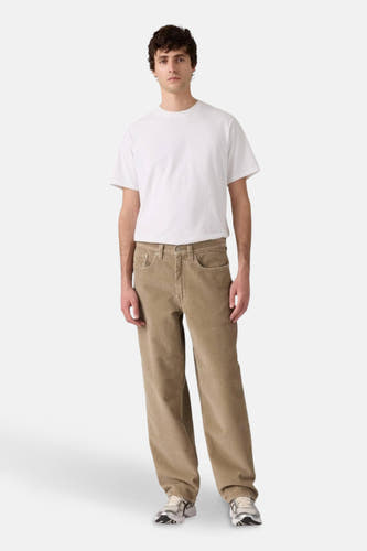 Jean en corduroy beige de Levi's, avec des poches et une jambe droite, porté avec un T-shirt blanc.