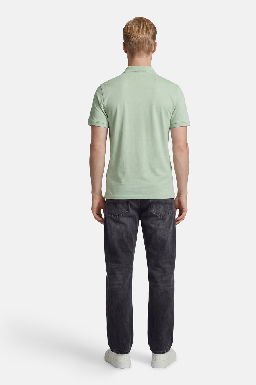 Polo verte Levi's® verte, dos, avec col côtelé.Porté avec un jean gris foncé et des baskets blanches.