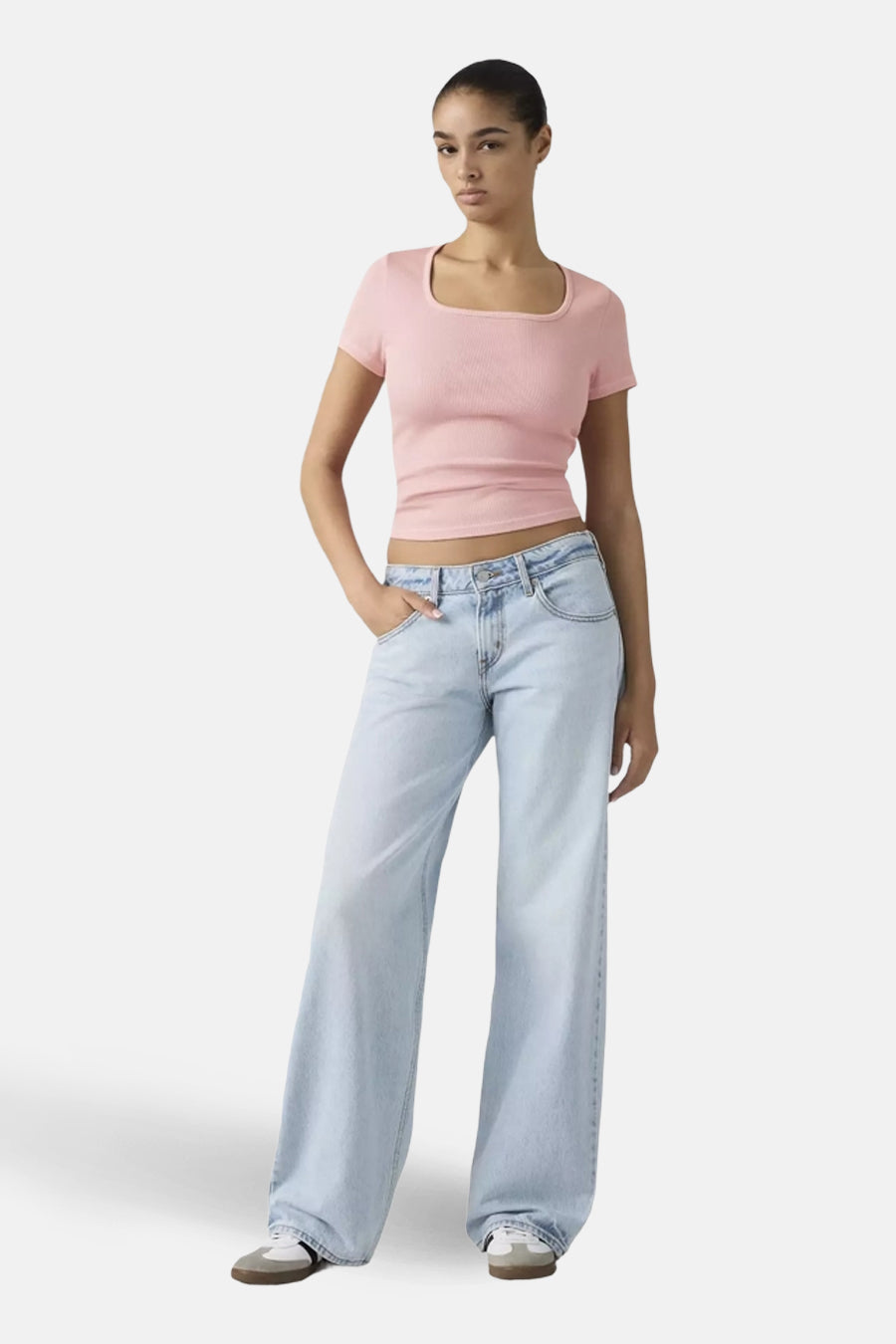 Wijdvallende jeans van lichtblauw denim van Levi's, gedragen met een roze top en witte sneakers.