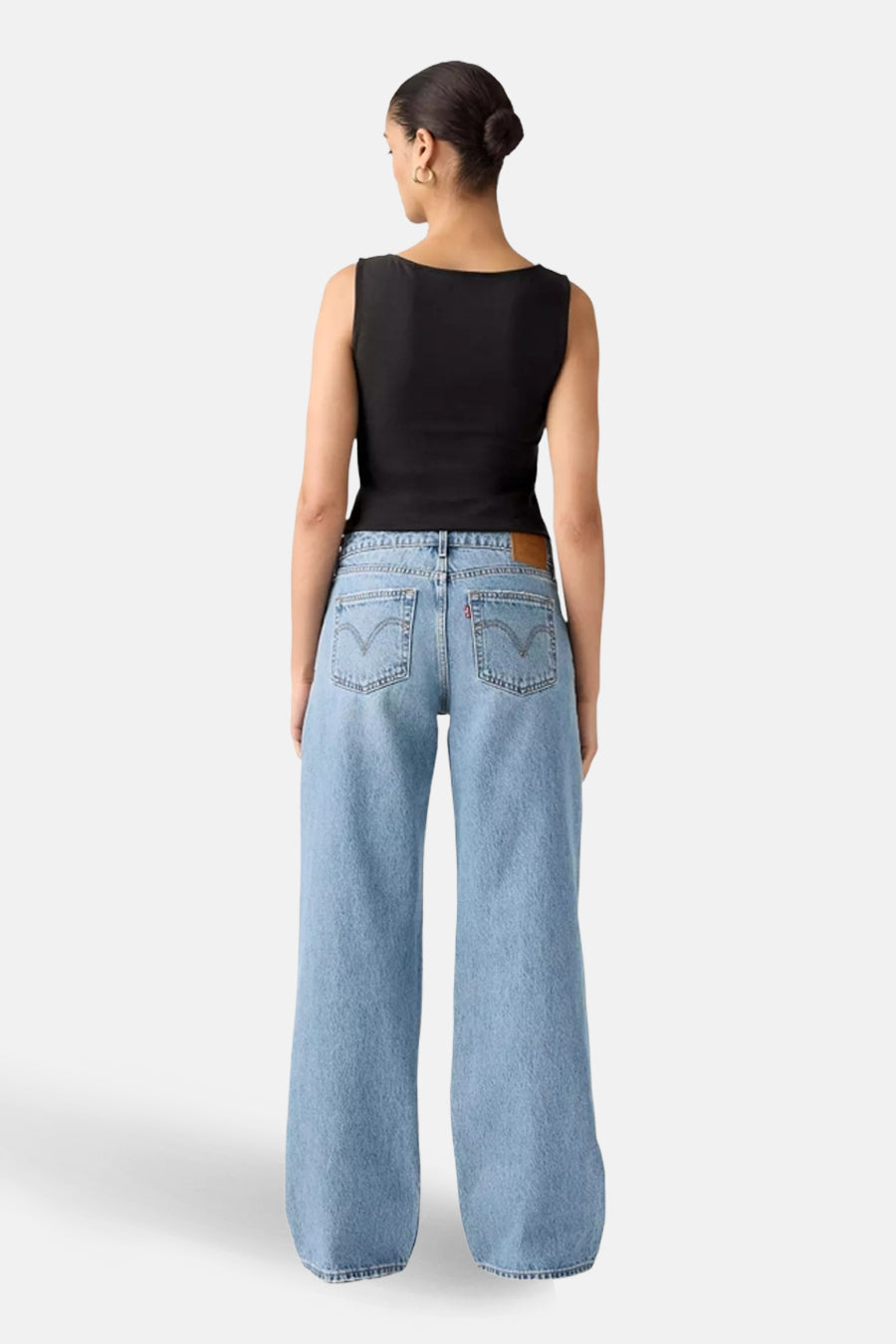 Wijde jeans van midblauw denim van Levi's®, met opgestikte achterzakken en een zwarte top.
