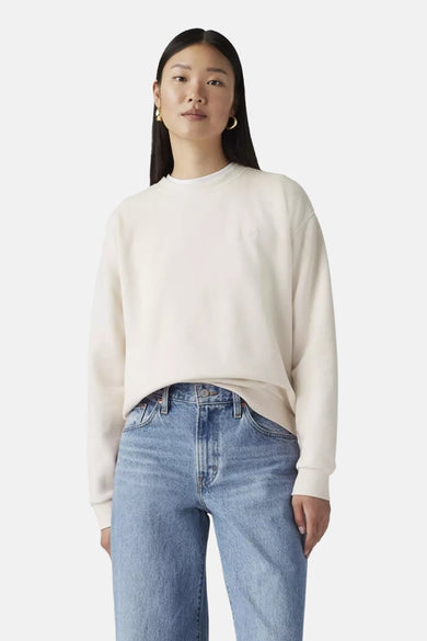 Witte ronde hals sweater van Levi's® met comfortabele pasvorm, gedragen met blauwe jeans en gouden oorbellen, front view.
