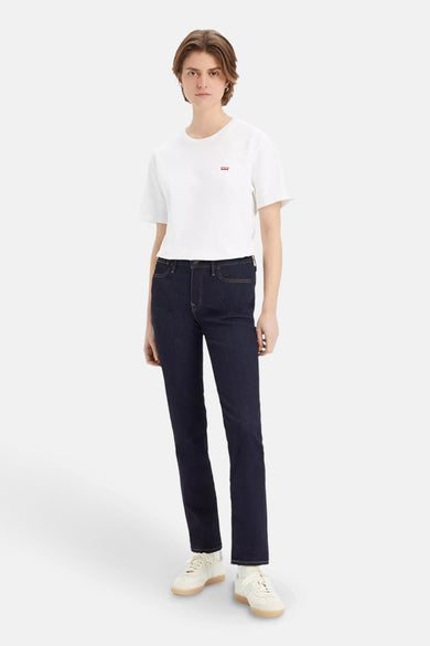 Jean slim bleu marine en denim de Levi's®, porté avec un T-shirt blanc et des baskets crème.