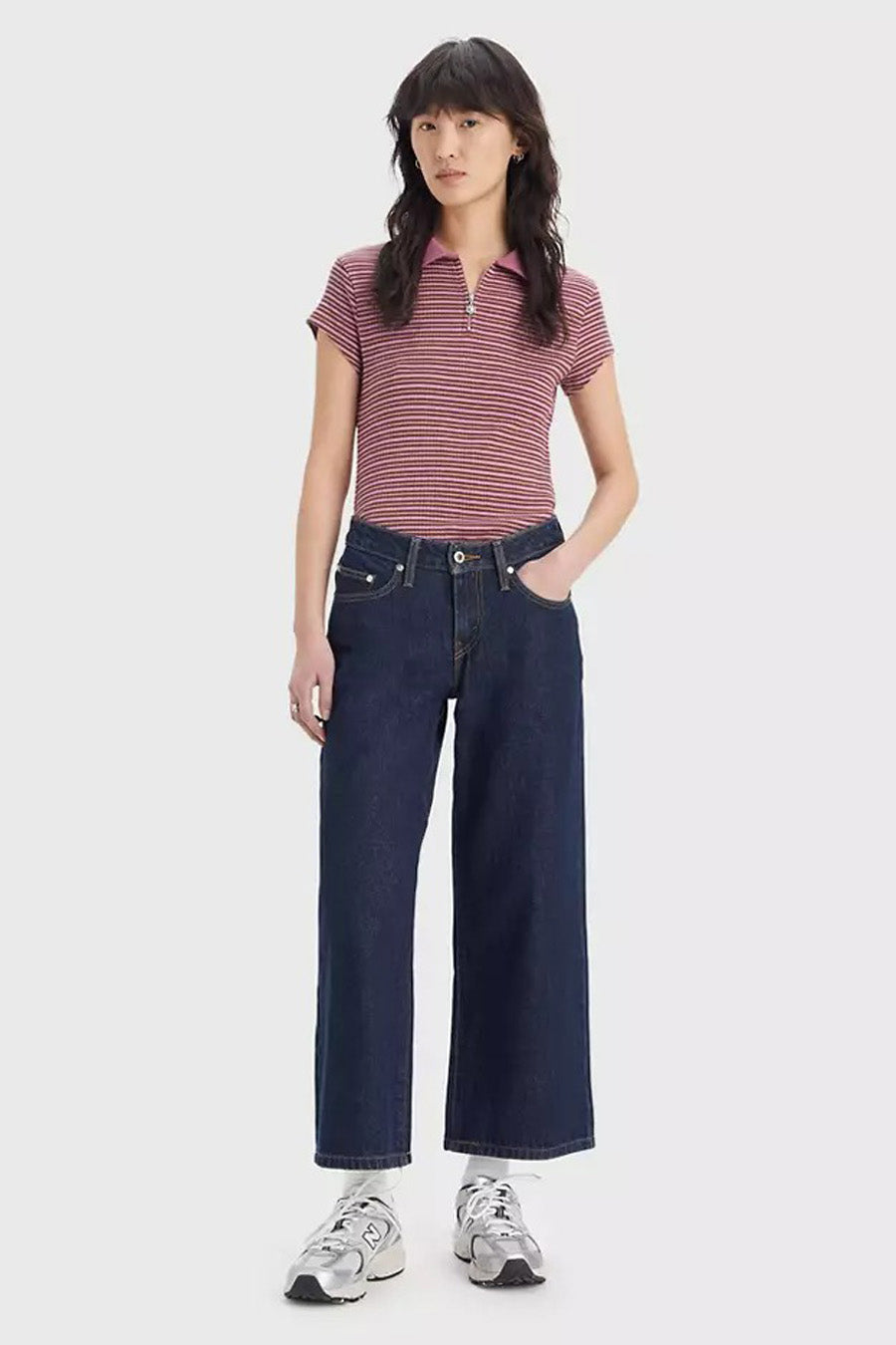 Jeans larges en denim bleu foncé de Levi's®, avec des coutures subtiles et portées avec un polo rayé.