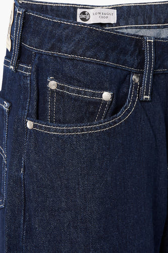 Jeans larges en denim bleu foncé de Levi's®, avec surpiqûres blanches et boutons métalliques.